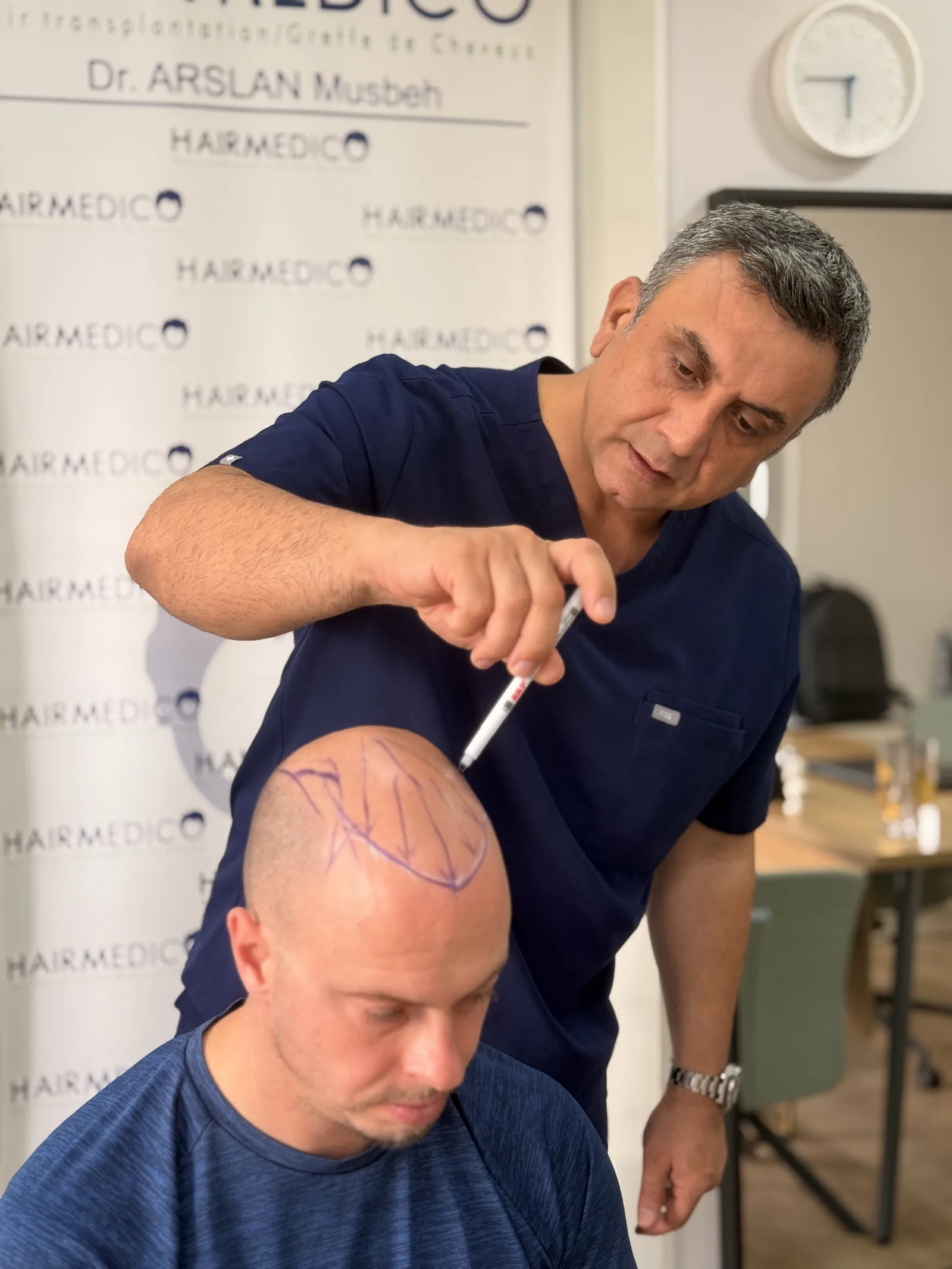 Dr. Arslan Musbeh marking a patient's hairline at the Hairmedico clinic before a transplant procedure
