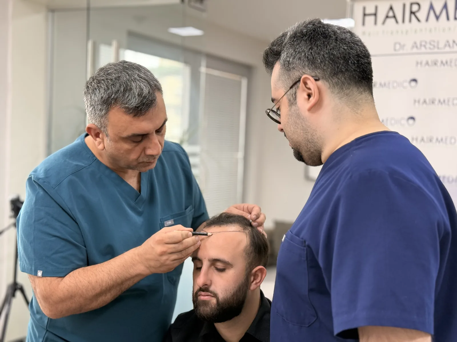 Dr. Arslan Musbeh marking a receding hairline before androgenetic alopecia hair transplant surgery