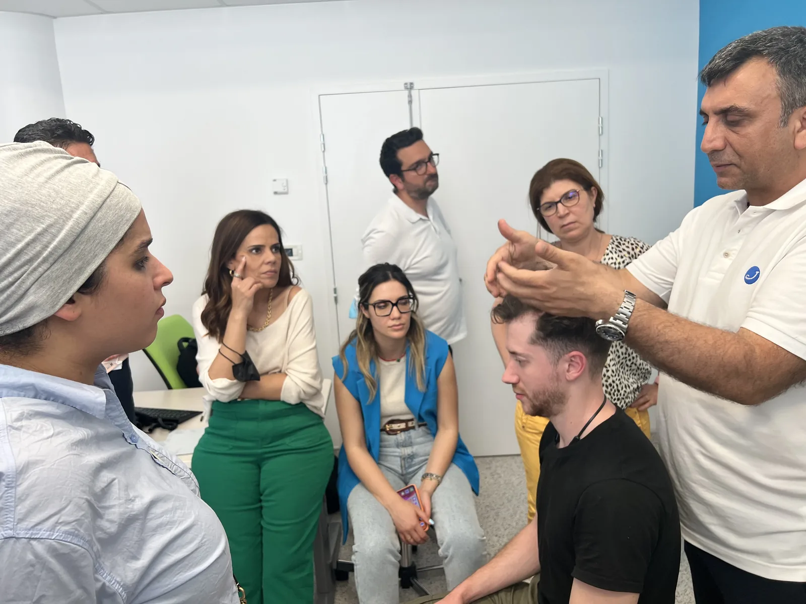 Dr. Arslan Musbeh reviewing a patient's scalp with the Hairmedico clinical team during a case discussion
