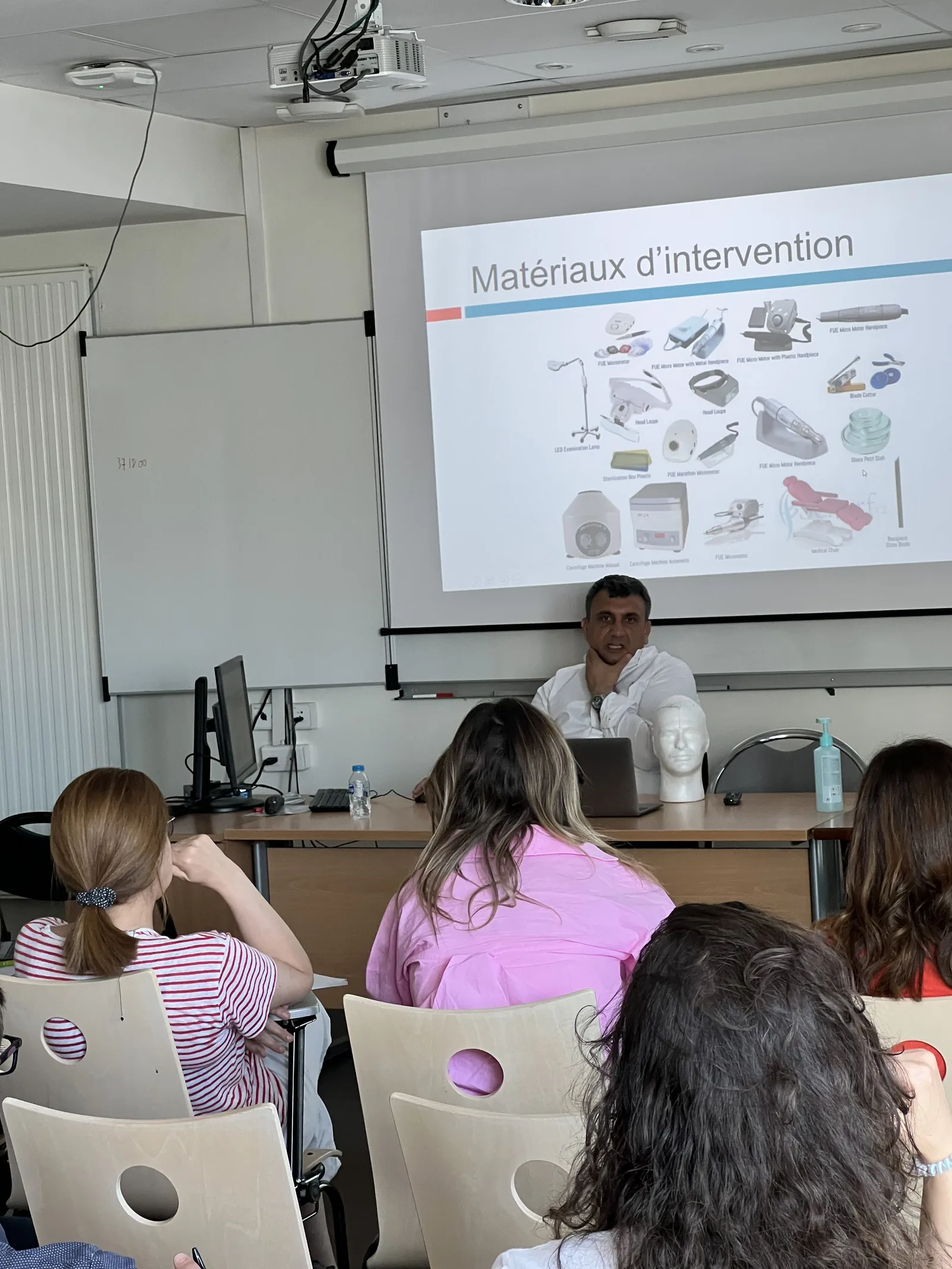 Dr. Arslan Musbeh presenting FUE intervention materials to fellow practitioners at an international training session