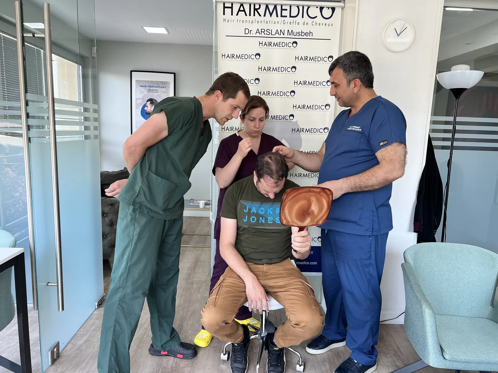 Dr. Arslan Musbeh and clinical team reviewing a patient's crown and scalp before a hair transplant plan is finalized