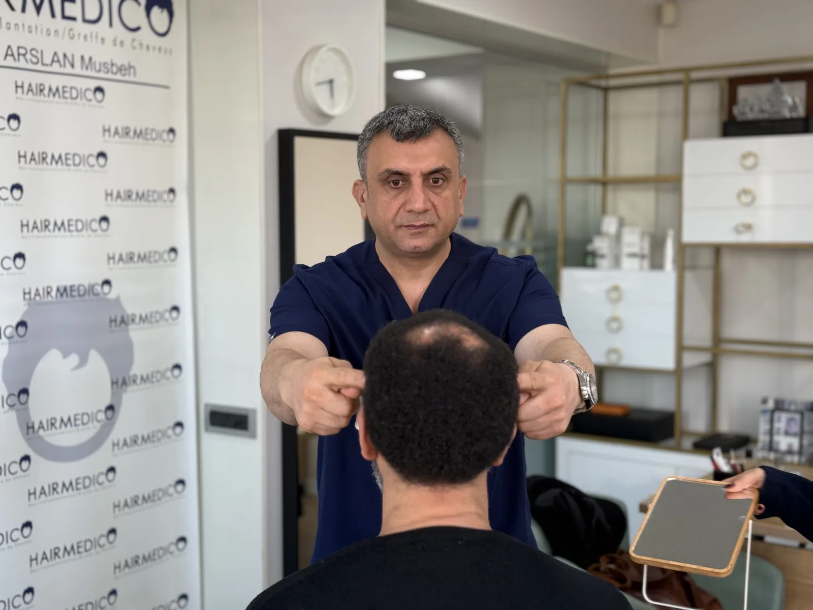 Dr. Arslan Musbeh examining a patient's donor and recipient areas at Hairmedico before selecting the extraction plan