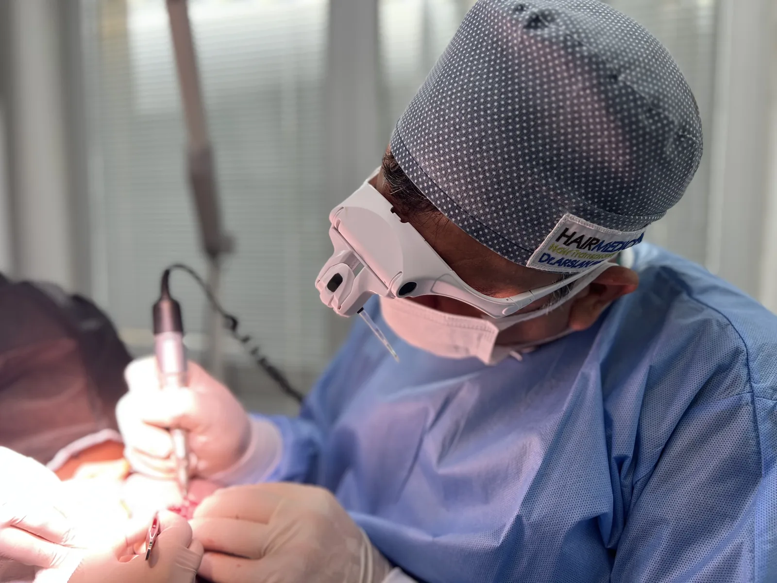 Dr. Arslan Musbeh performing FUE graft extraction under surgical loupes at Hairmedico Istanbul