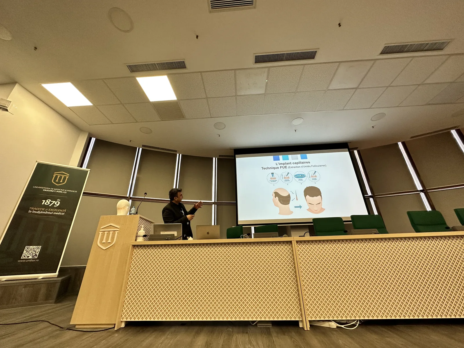 Dr. Arslan Musbeh lecturing on FUE hair transplant technique at a university medical congress in Iași, Romania