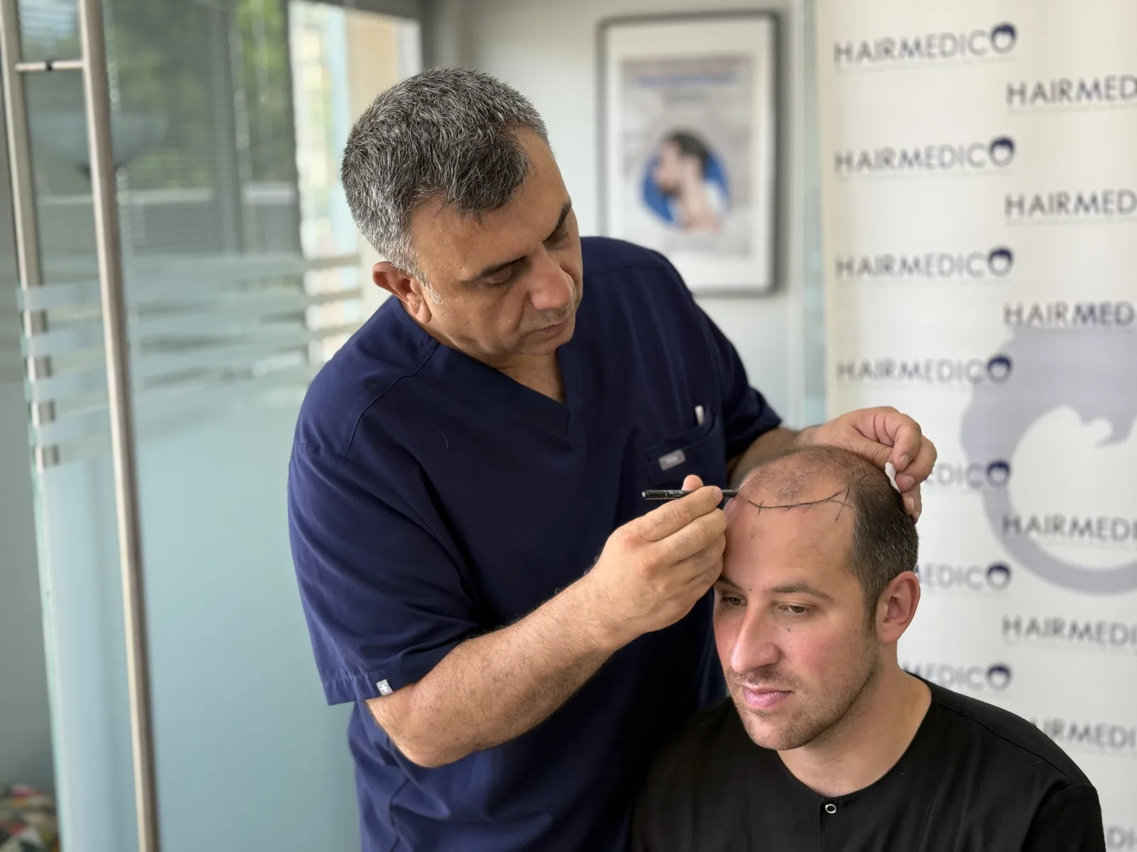 Dr. Arslan Musbeh personally marking a patient's hairline before surgery at the Hairmedico clinic