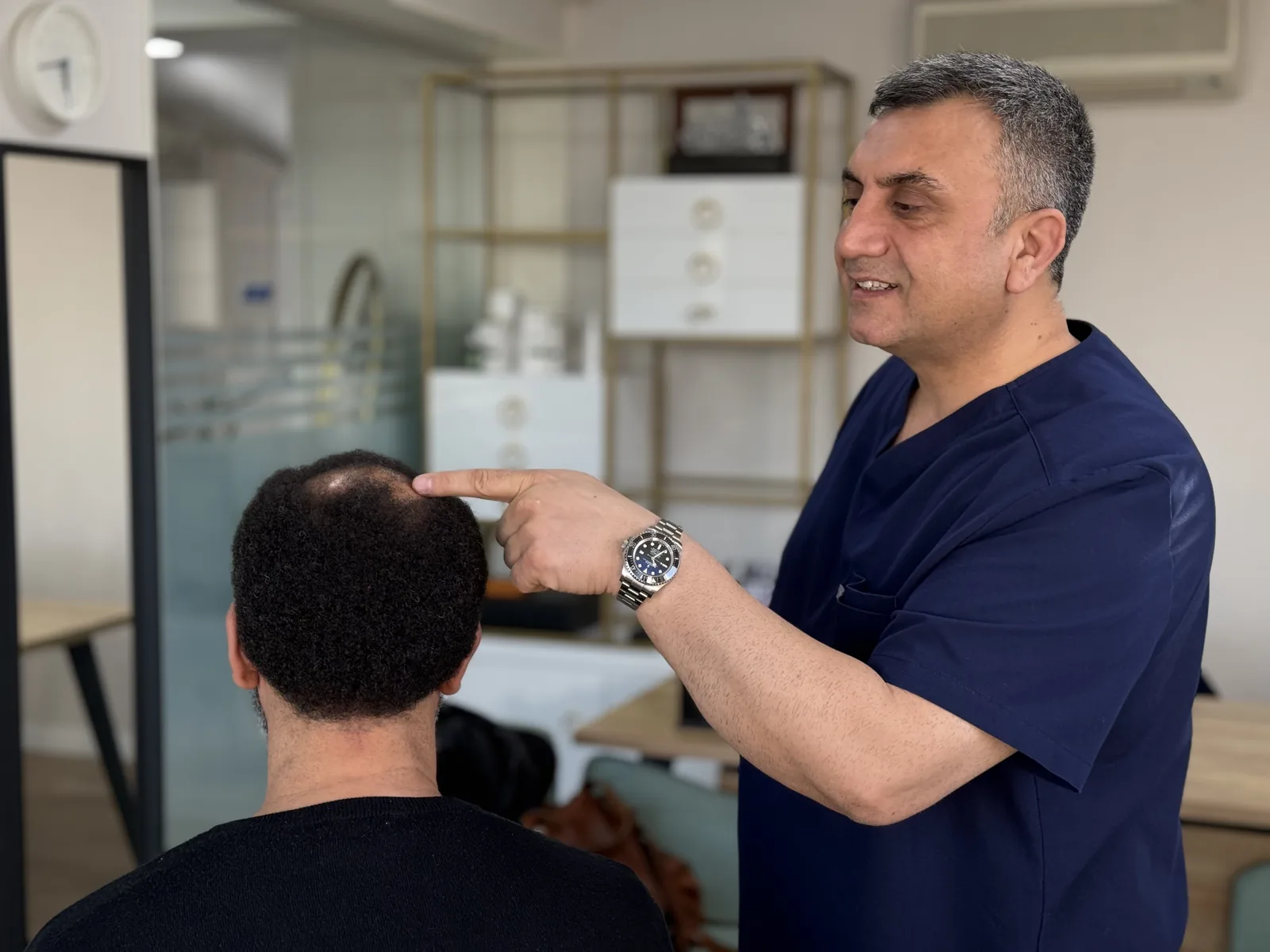 Dr. Arslan Musbeh marking the recipient area on a patient's scalp to plan graft angle and direction