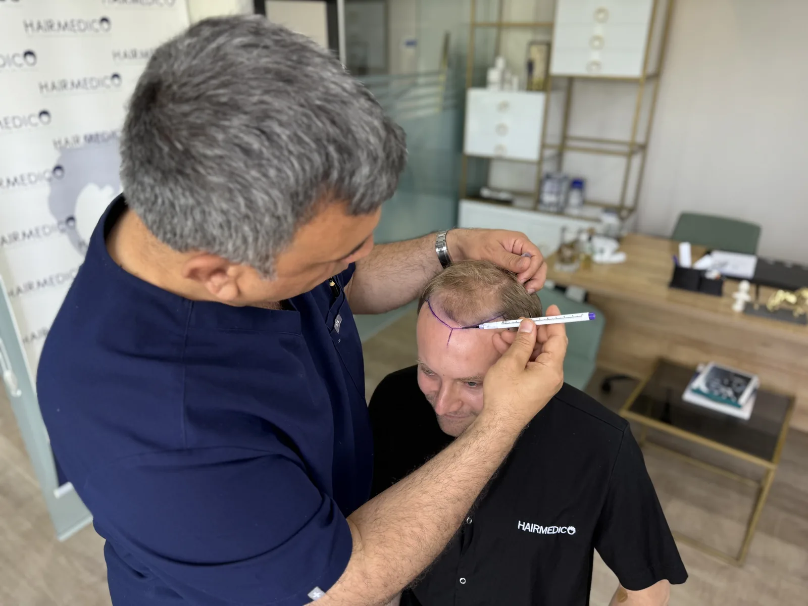 Dr. Arslan Musbeh personally measuring and marking a patient's hairline before surgery at Hairmedico Istanbul