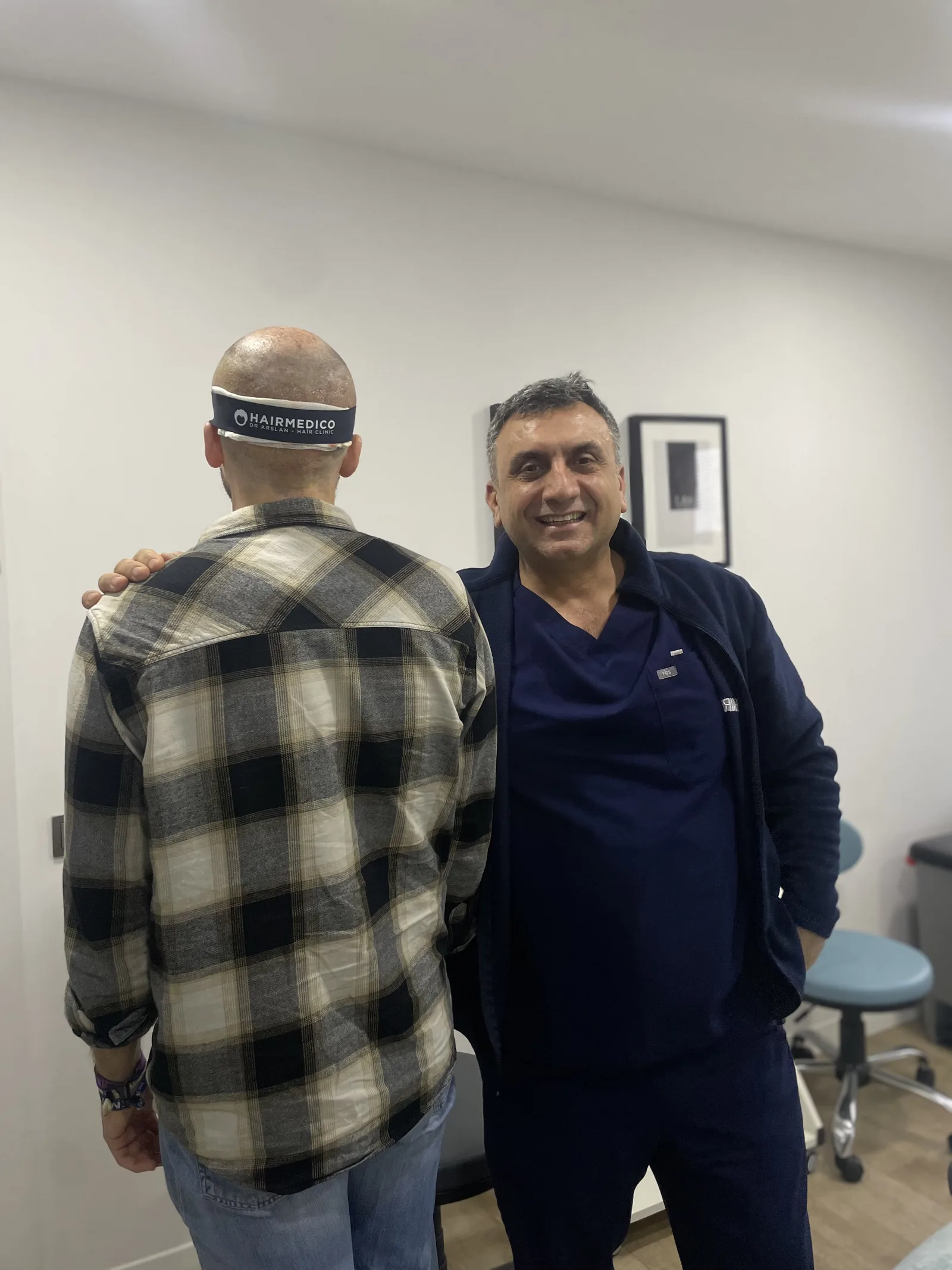 Patient wearing Hairmedico protective headband with Dr. Arslan Musbeh after hair transplant surgery