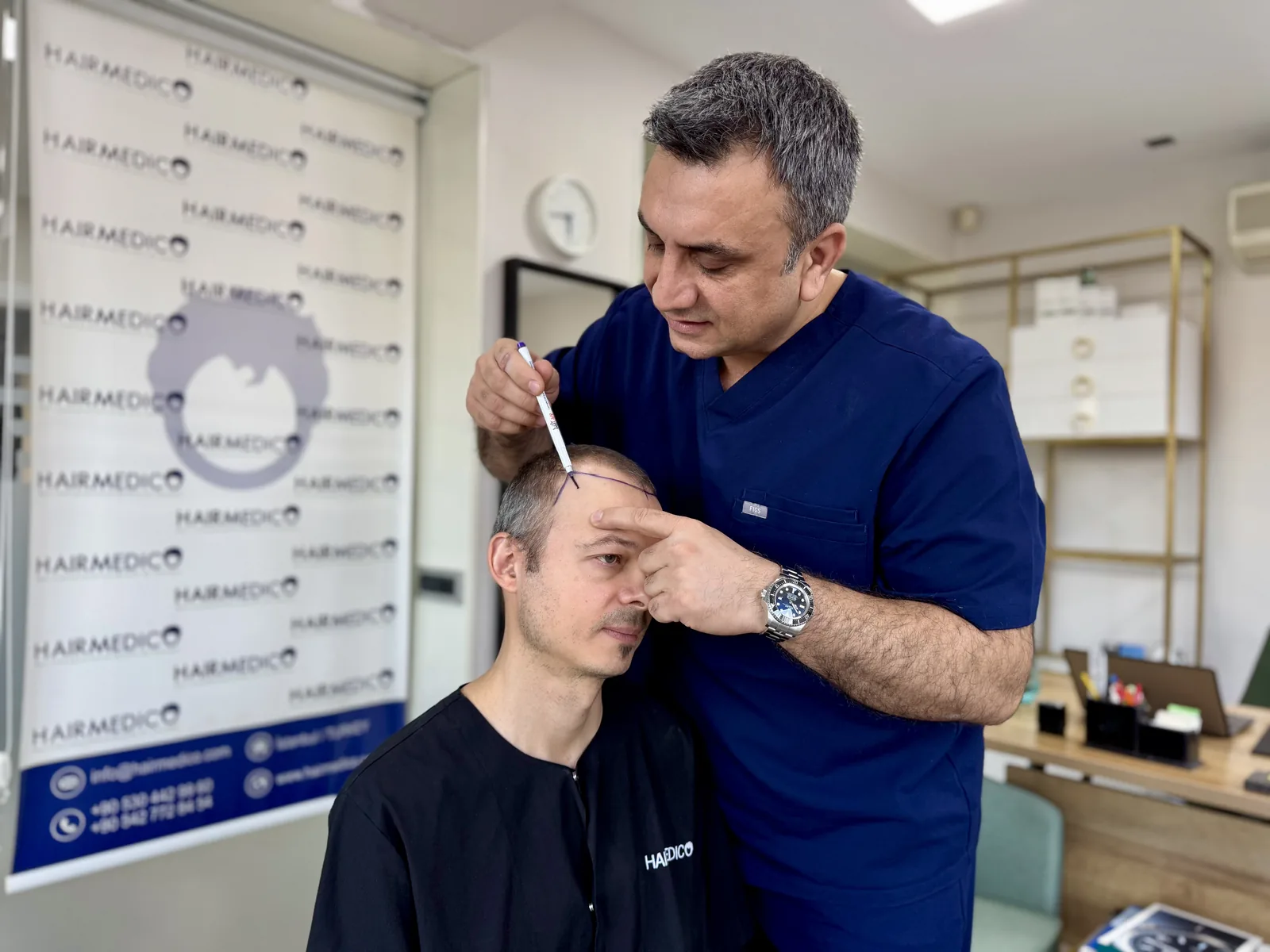 Dr. Arslan Musbeh personally marking a patient's hairline with a surgical pen before FUE surgery at the Hairmedico clinic