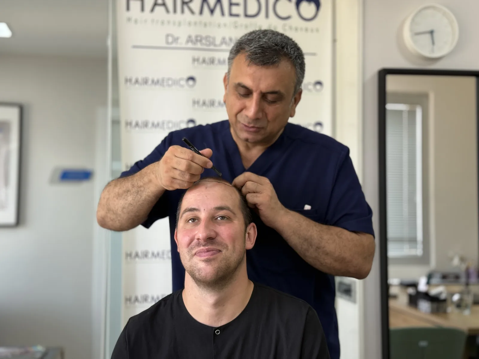 Dr. Arslan Musbeh drawing a patient's hairline by hand during the pre-operative consultation at Hairmedico Istanbul