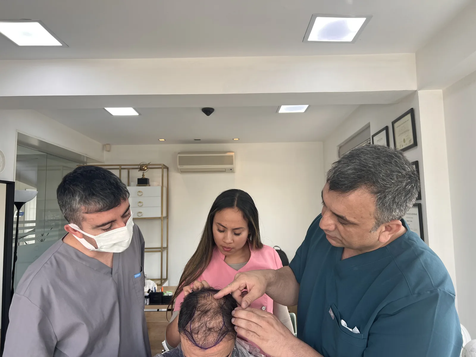Dr. Arslan Musbeh and his clinical team reviewing a patient's hairline design together before a procedure