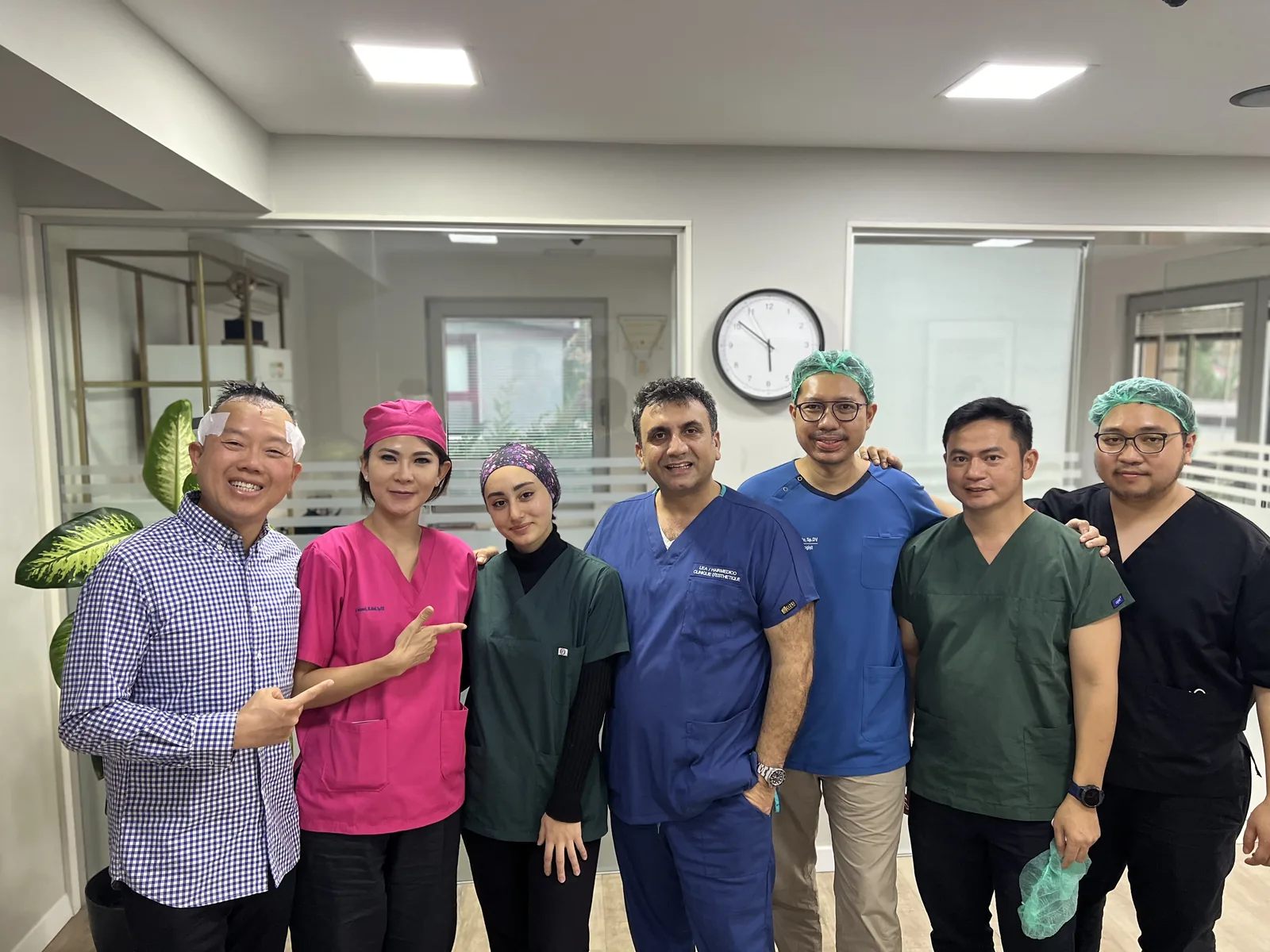 Dr Arslan Musbeh and the surgical team with a patient shortly after his hair transplant, dressing still in place