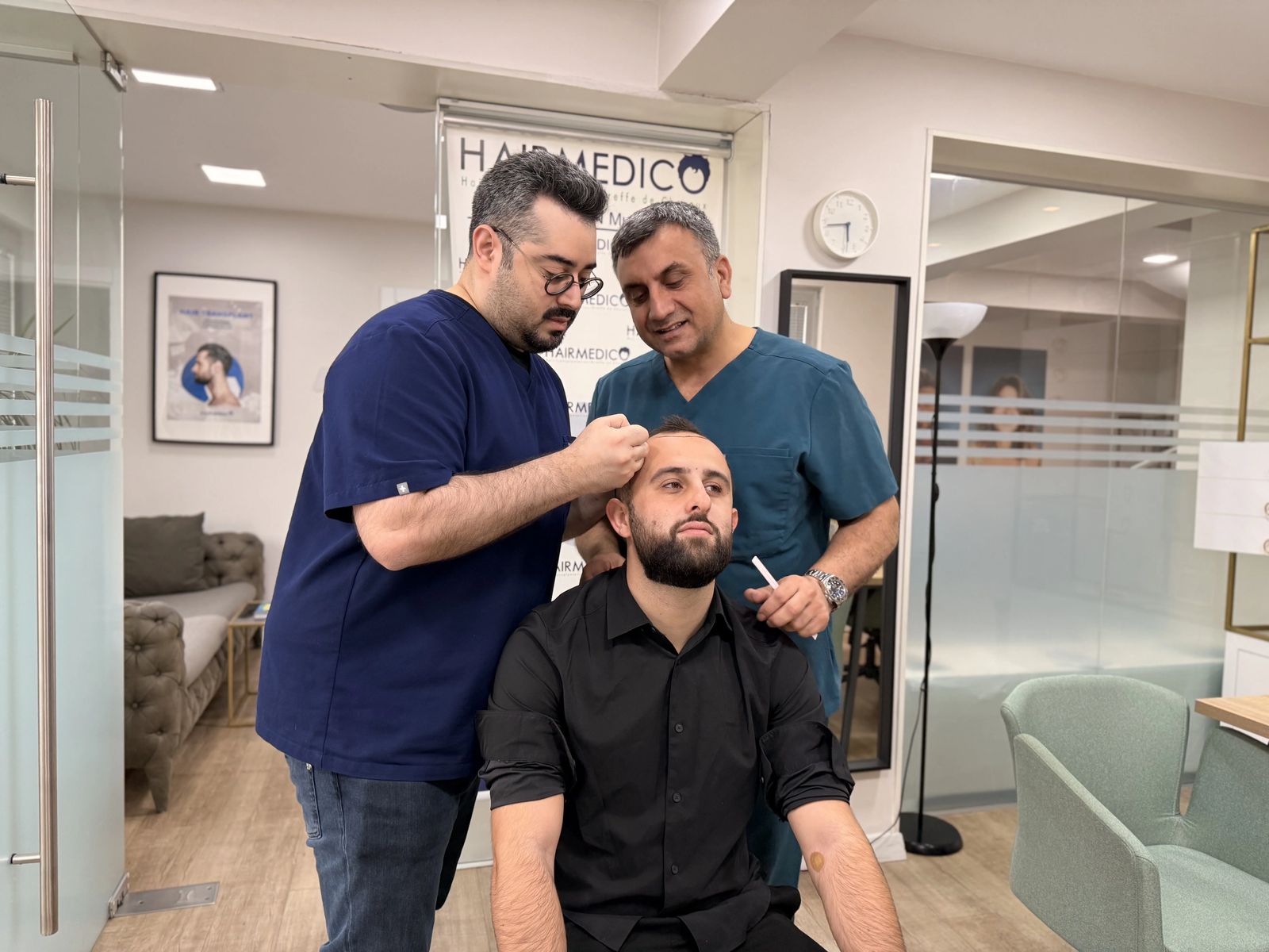 Dr Arslan Musbeh examinant le cuir chevelu d'un patient en consultation