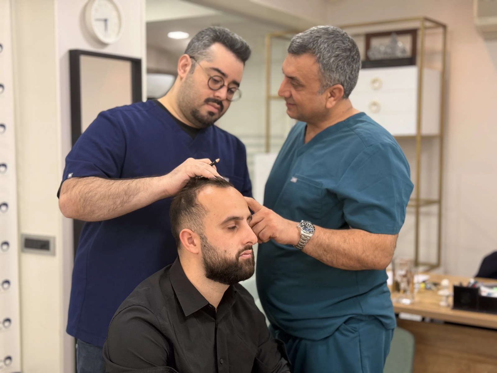 Dr Arslan Musbeh examinant le cuir chevelu d'un patient en consultation