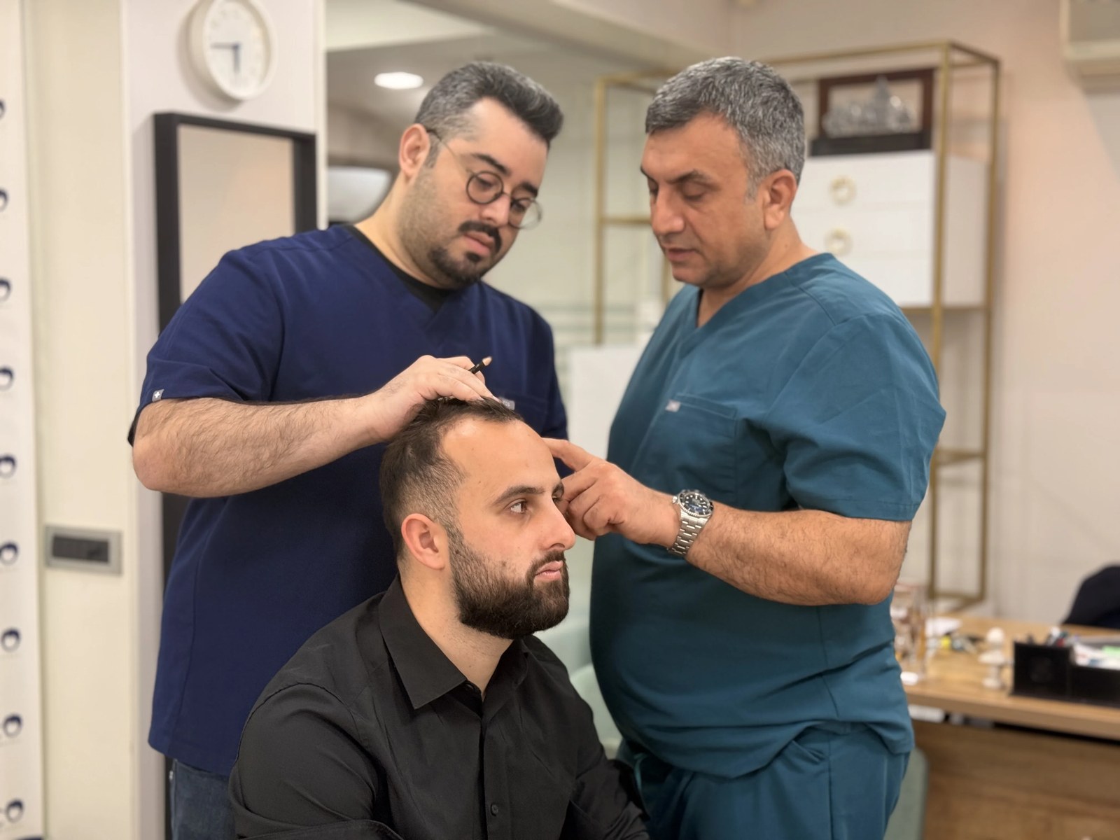 Dr Arslan Musbeh examinant le cuir chevelu d'un patient en consultation