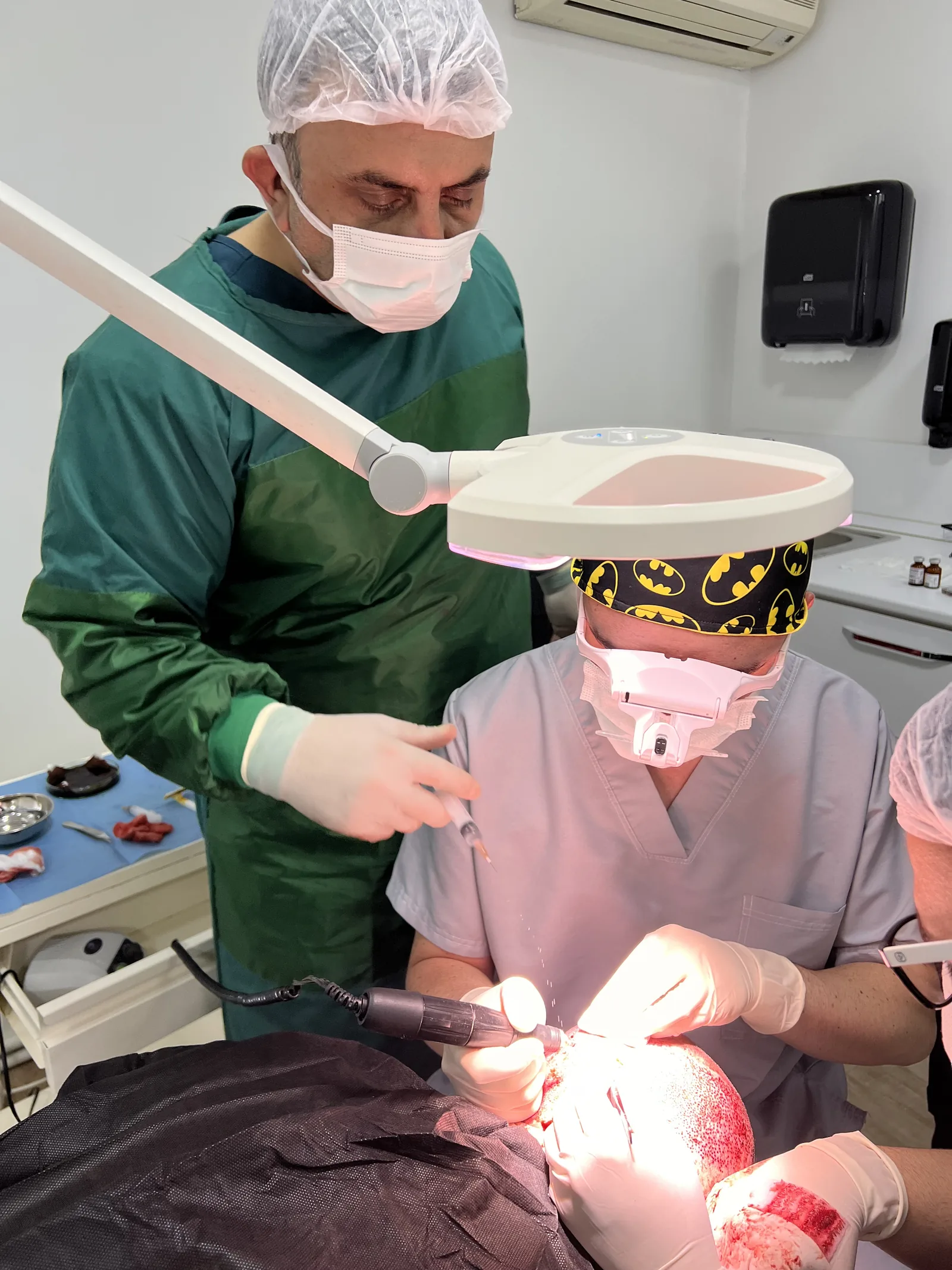 Hairmedico's clinical team performing an FUE extraction under surgical lighting at the Levent, Istanbul facility — the same environment reviewed for health tourism authorisation