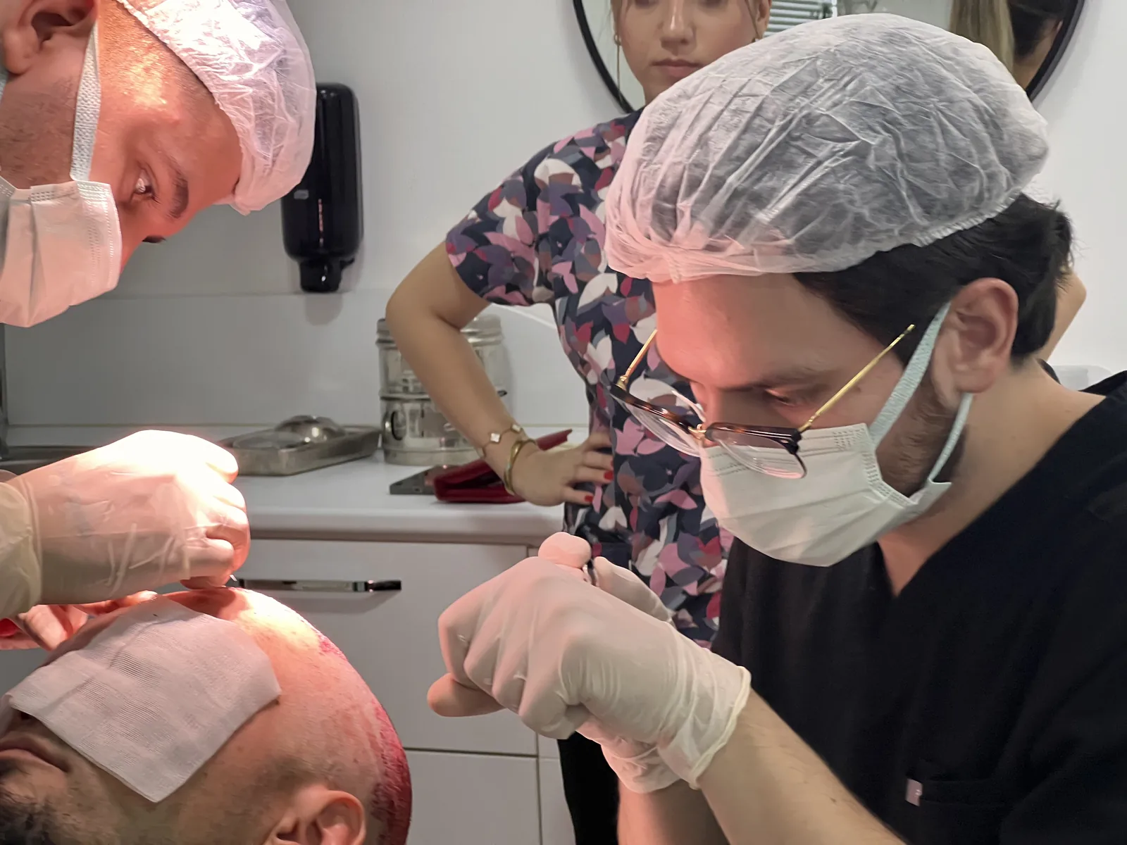 Hairmedico clinical team working on graft placement along a patient's hairline during an FUE procedure