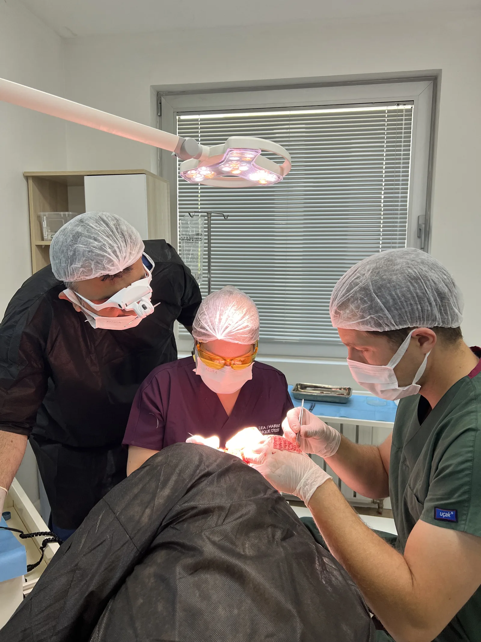 Dr. Arslan's surgical team performing graft work under magnification during a hair transplant procedure