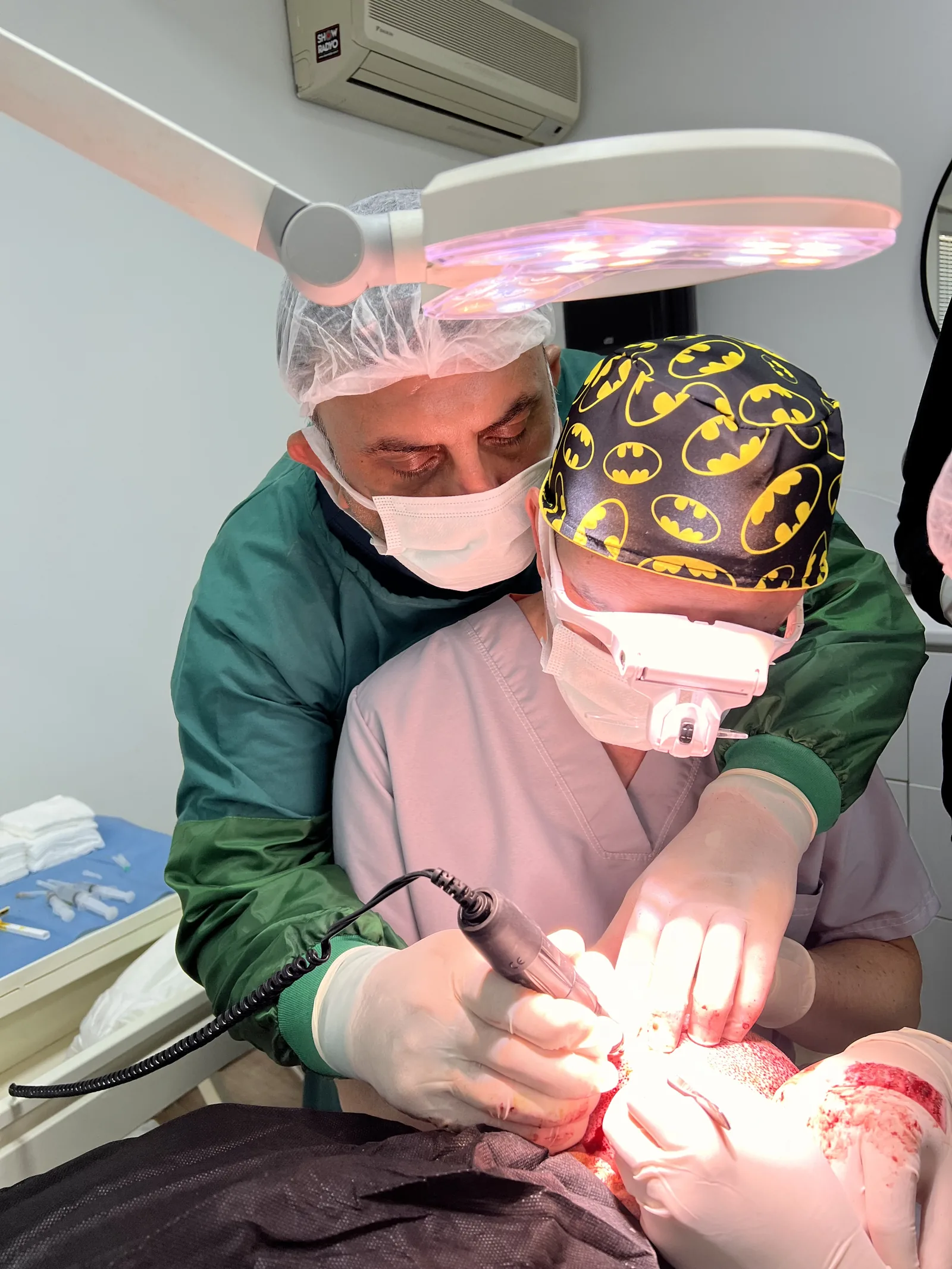 Hairmedico surgical team collaborating during a hair transplant procedure in a sterile treatment room, Istanbul